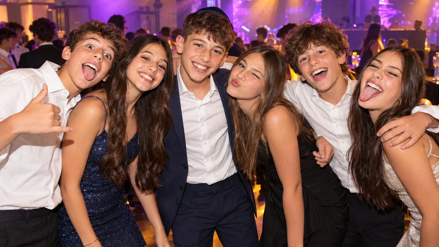חברים בני שלוש עשרה מצטלמים יחד בבר מצווה ועושים פרצופים מצחיקים, מול אורות במה סגולים וכתומים